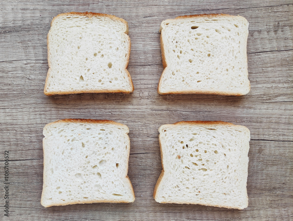 Square pieces of white toast bread on a wooden background Square pieces of white toast bread on a wooden background