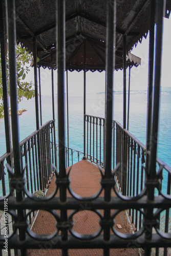 Rustic Metal Gazebo with Rusty Spiral Stairs Leading Toward the Sea, Surrounded by Greek Island Landscape