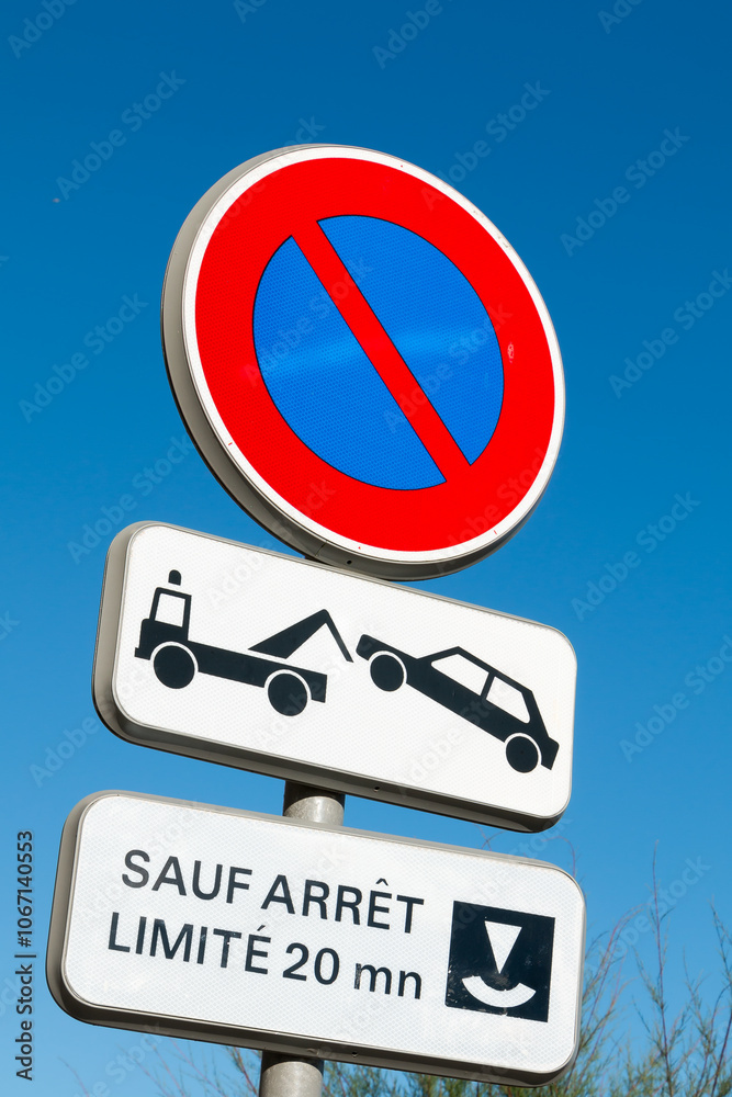 Road sign prohibiting parking in France with sign Except Stop limited to 20 mins