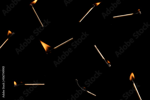 Lit falling match on a black background.