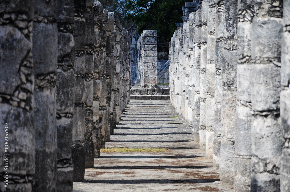 Ancient stone columns of Chichen Itza creating a historic pathway with shadows Ancient stone columns of Chichen Itza creating a historic pathway with shadows