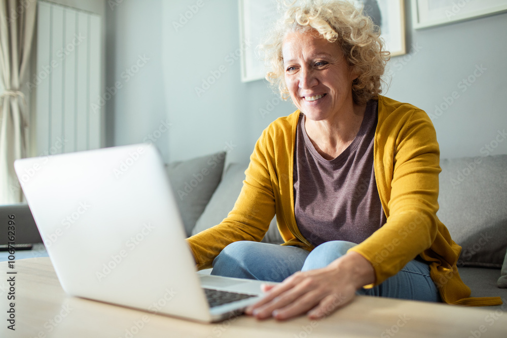 Woman working on laptop checking emails on the sofa at home Woman working on laptop checking emails on the sofa at home