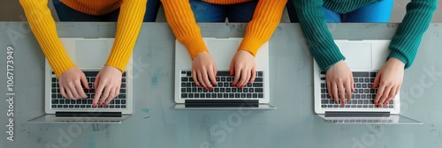 Three Women Typing on Laptops in Colorful Sweaters from Above photo