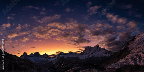 amazing sunset panorama over snowy mountain range with big glaciers with red, orange, violet and moonlight colors