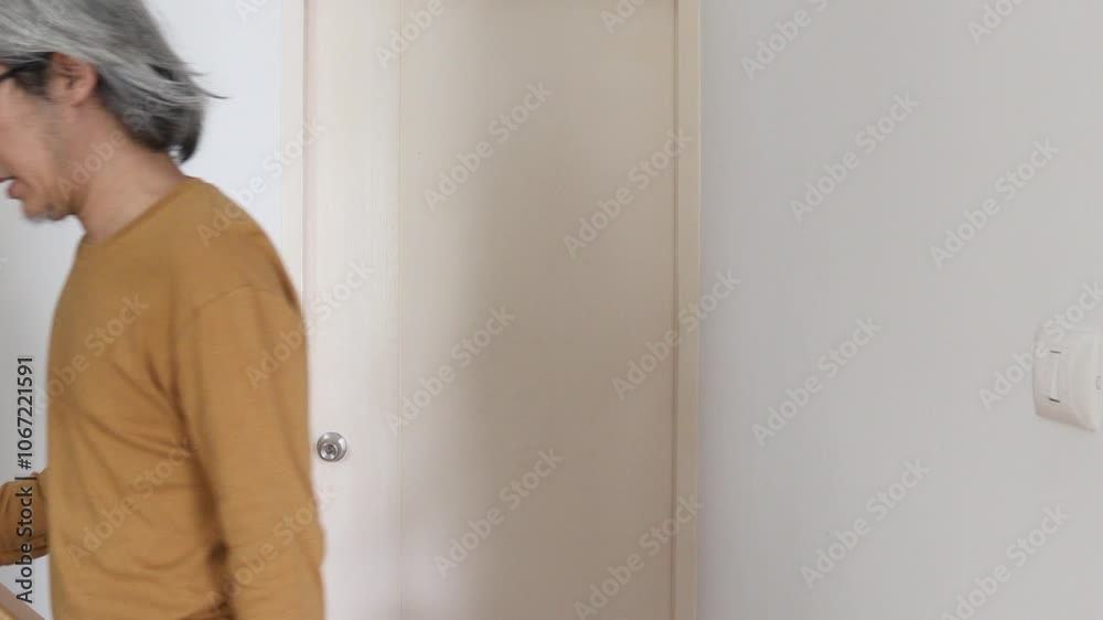 The senior Asian man open the door in the house. The senior Asian man open the door in the house.