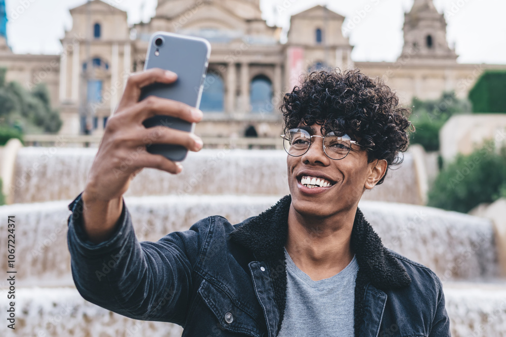 Cheerful black man taking selfie at waterworks edge with smartphone Cheerful black man taking selfie at waterworks edge with smartphone