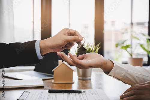 Realtor agent giving a key of apartment to new owner after signed lease agreement.