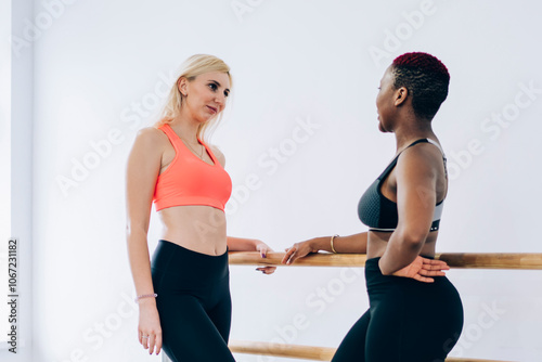 Diverse sportswomen chatting during break at exercise room photo