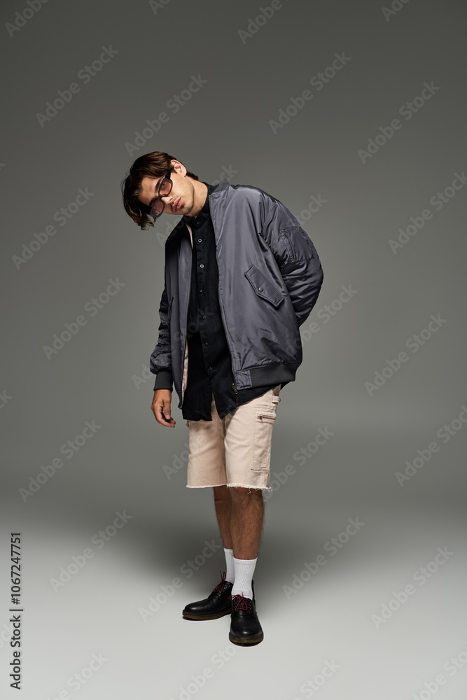 A young man showcases his fashionable autumn outfit, expressing individuality with a confident pose. A young man showcases his fashionable autumn outfit, expressing individuality with a confident pose.