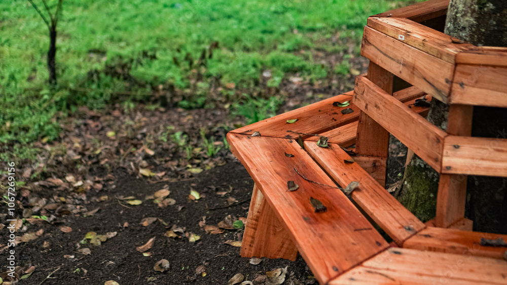 A wooden bench encircles a tree trunk in a lush green park. The bench is made of weathered wood planks and offers a cozy spot to sit and enjoy the outdoors. A wooden bench encircles a tree trunk in a lush green park. The bench is made of weathered wood planks and offers a cozy spot to sit and enjoy the outdoors.