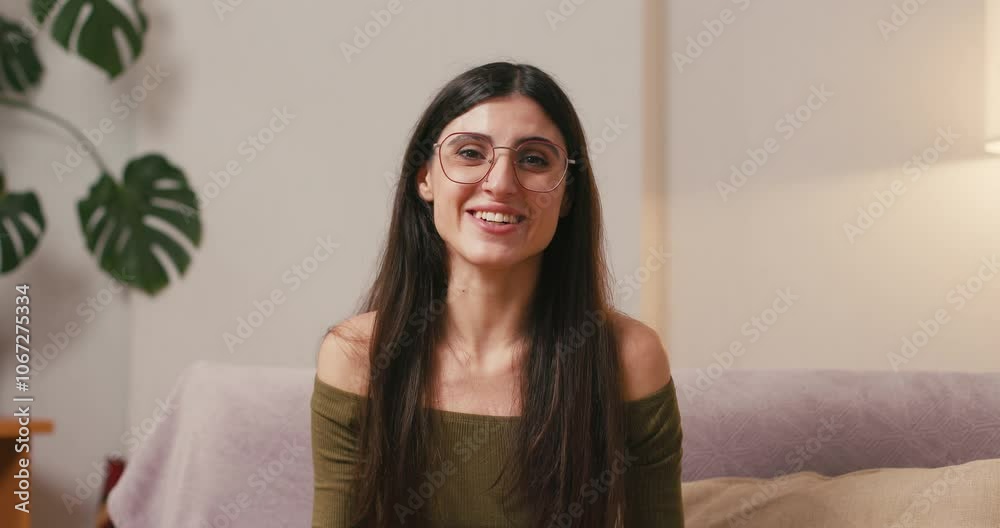 Brunette woman waves hand expressing warm greeting to interlocutor Brunette woman waves hand expressing warm greeting to interlocutor