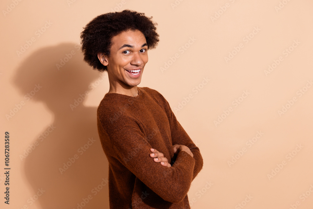 Smiling young man with crossed arms in casual outfit against beige background confidence joy. Perfect for advertising, promotion lifestyle concepts. Smiling young man with crossed arms in casual outfit against beige background confidence joy. Perfect for advertising, promotion lifestyle concepts.