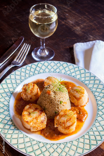 Seared scallops and Quinoa pilaf plate on table