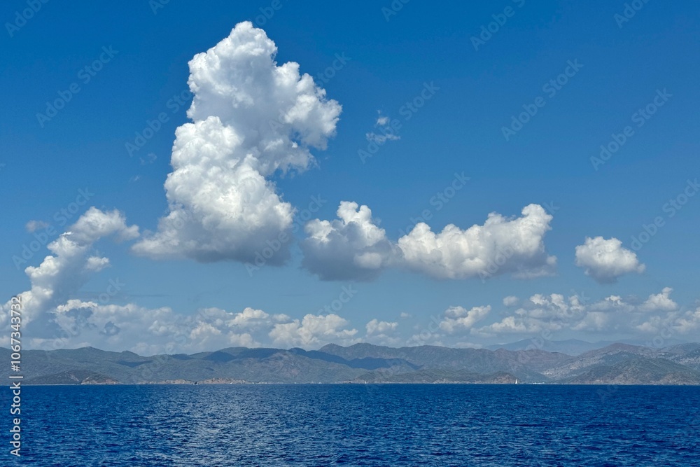A abstract formation of white clouds on the blue sky above water in Fethiye Bay in Turkey
