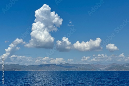 Obraz na płótnie A abstract formation of white clouds on the blue sky above water in Fethiye Bay in Turkey
w salonie