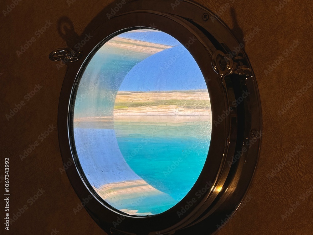 The beautiful view of the water and the sky through the cabin port window in Mediterranean Sea
