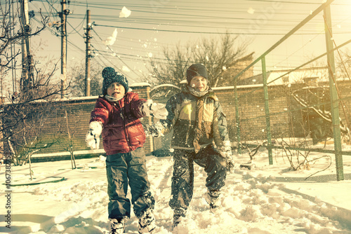 Two boys play with snow. Happy childhood. Brothers on a walk. two kids playing with snow. toned.