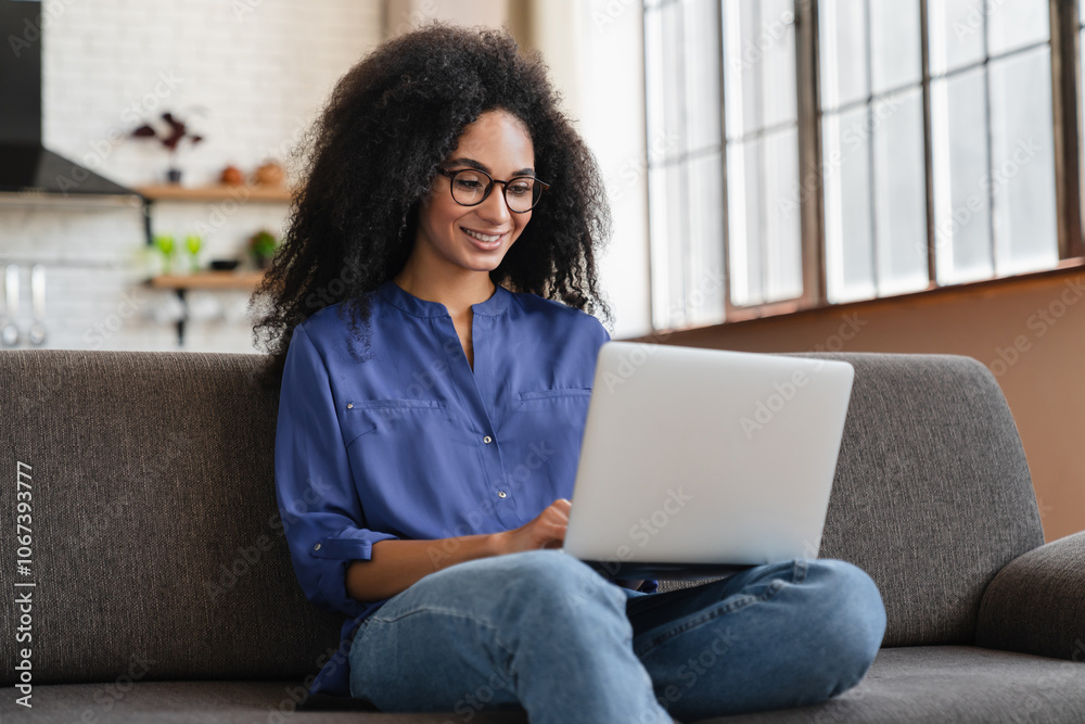 Stockfoto Concentrated millennial girl sit on couch working on laptop ...