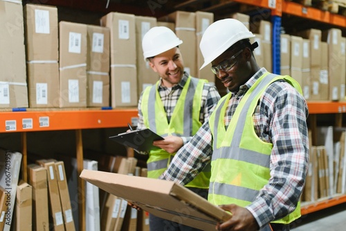 Two warehouse workers checking and controlling boxes in warehouse, Professional warehouse workers