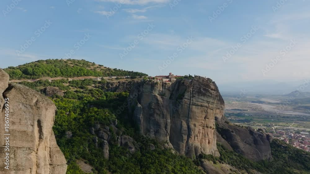 Captivating scenery features a monastery perched on a towering rock formation in Meteora, Greece, showcasing stunning architecture against dramatic clouds and majestic mountains Captivating scenery features a monastery perched on a towering rock formation in Meteora, Greece, showcasing stunning architecture against dramatic clouds and majestic mountains