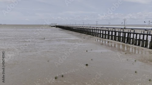 Drone flies at an angle along water treatment pipes on pier on Amazon River in Macapá, Amapá, Brazil