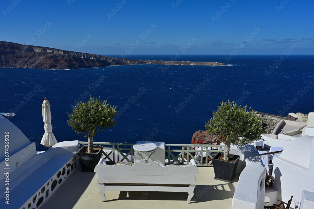 Obraz premium Eine schöne Terrasse auf einer Mediterranen Insel mit Blick auf das blaue Meer an einem Sonnigen Tag und man sieht noch eine benachbarte Insel.