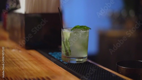 A closeup image of a refreshing cocktail, garnished with mint leaves and lime slices, elegantly presented on a rustic bar counter, ideal for summer gatherings and celebrations with friends