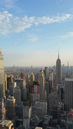 The breathtaking panoramic view showcases the iconic New York City skyline, featuring landmarks such as the Empire State Building and One World Trade Center against a beautiful clear sky