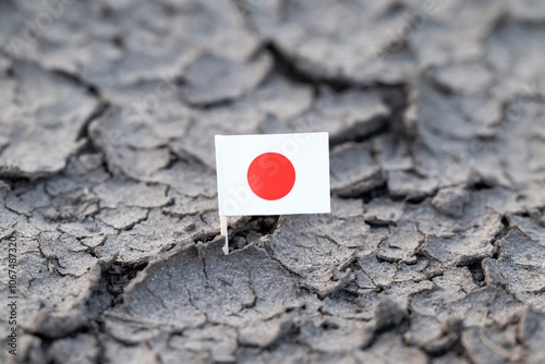 Flag of Japan in dry cracked dirt due to drought. Concept of hot rainless weather in Japan
