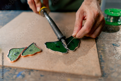 Photography close up in a large green workshop on a woman with green hair creates decorative