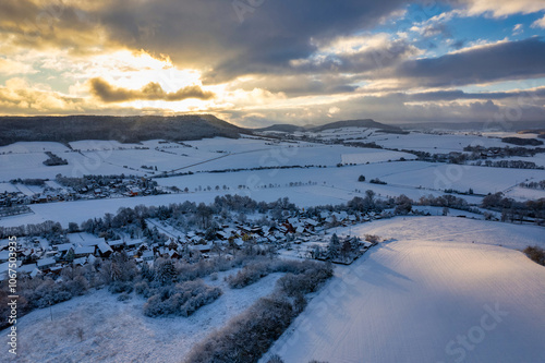 Obraz na płótnie Aerial view of a small German mountain village covered by heavy snow at sunset. Germany. w salonie