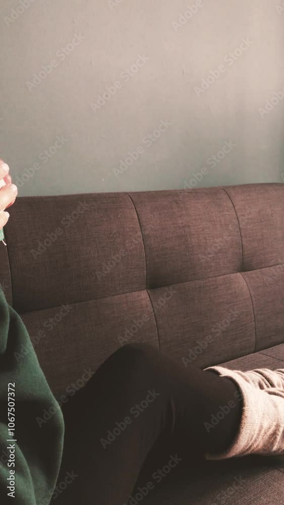 Young woman drinking on a cozy and comfy couch