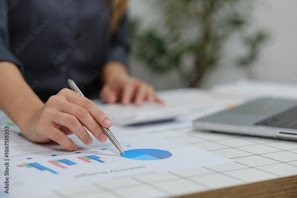A woman is working on a graph with a pen on a table A woman is working on a graph with a pen on a table