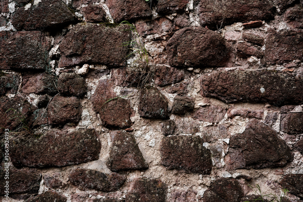 A wall made of stone with a rough texture. The wall is brown and white