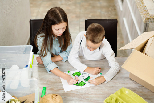 Сhildren paint symbol recycle. Kids sort paper and plastic into sorting bin in the kitchen at home. Waste segregation, waste sorting, waste recycle.