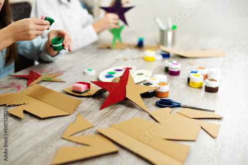 Handmade stars from cardboard. Eco-friendly handicraft and Christmas decorations and ornaments. Children design cardboard decorations.