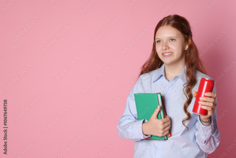 Smiling teenage girl with books and can on pink background. Space for text Smiling teenage girl with books and can on pink background. Space for text