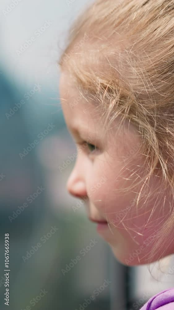 Pretty little girl in purple blouse looks at passing by blurry cabin of modern ropeway at picturesque highland close side view slow motion Pretty little girl in purple blouse looks at passing by blurry cabin of modern ropeway at picturesque highland close side view slow motion