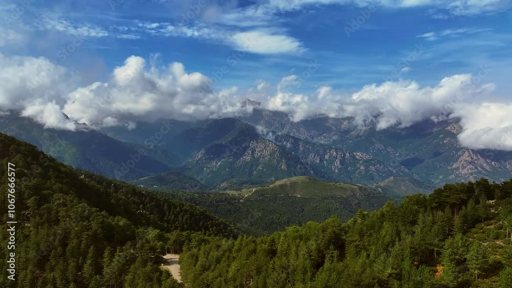 Stunning panoramic view of lush green mountains under a cloudy blue sky in the early morning light. Corsica Stunning panoramic view of lush green mountains under a cloudy blue sky in the early morning light. Corsica