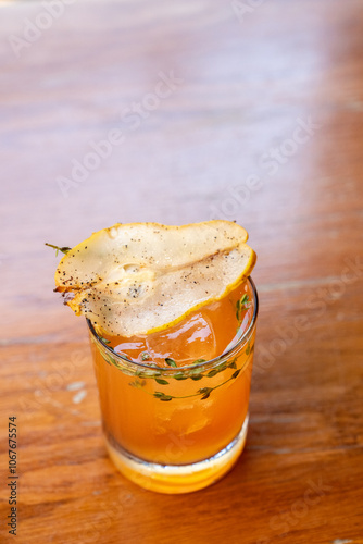 Fall pear cocktail with pear and thyme garnish 