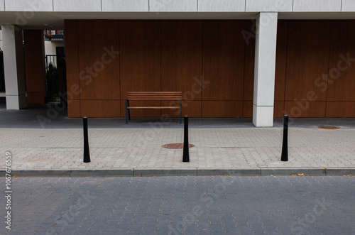 The modern facade of a European apartment building with a bench next to it in brown tones