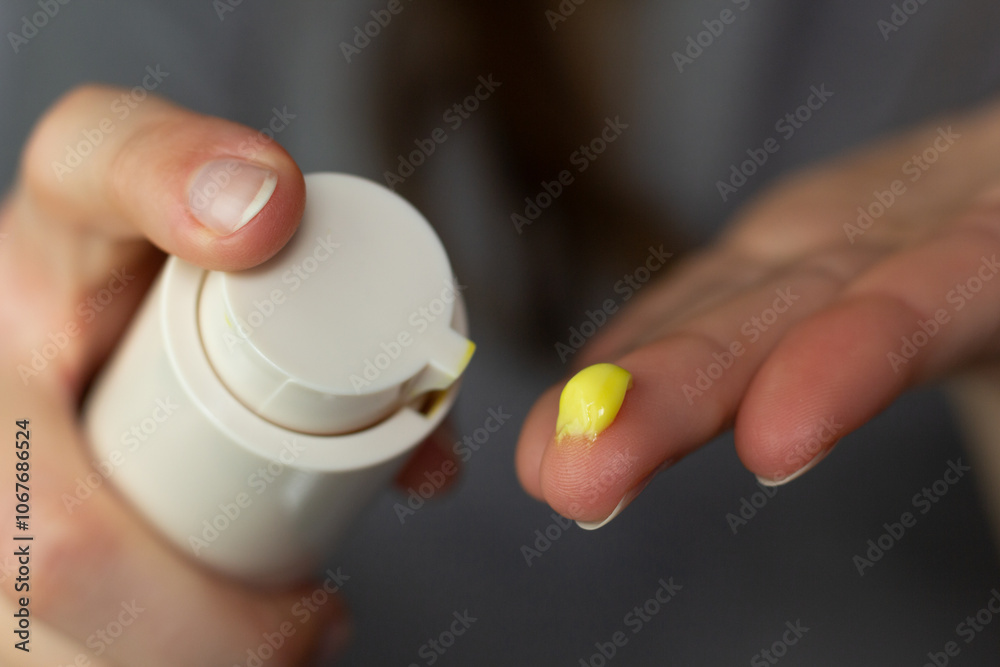 Closeup of a woman using a retinol cream.
