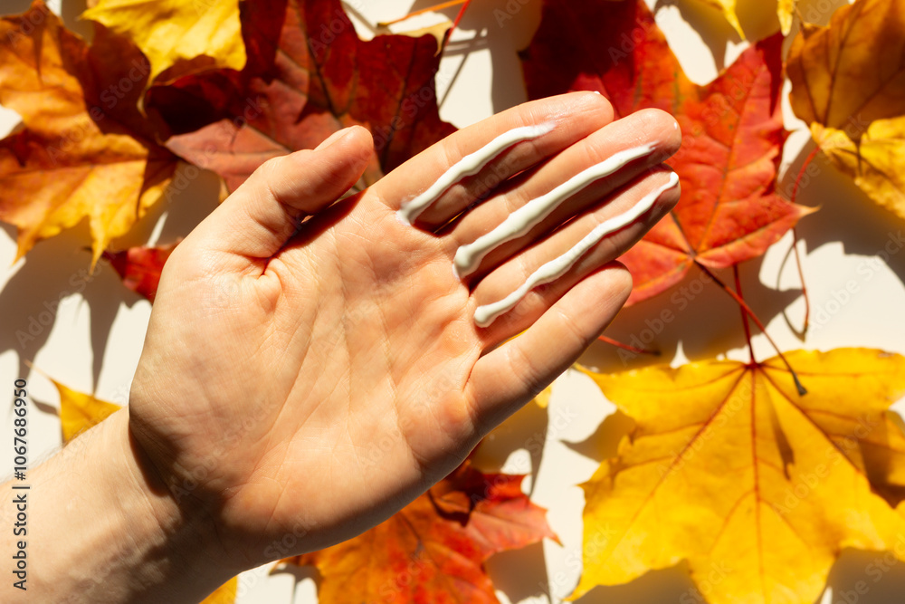 Closeup of a person applying the correct amount of sunscreen in autumn using the three finger rule.