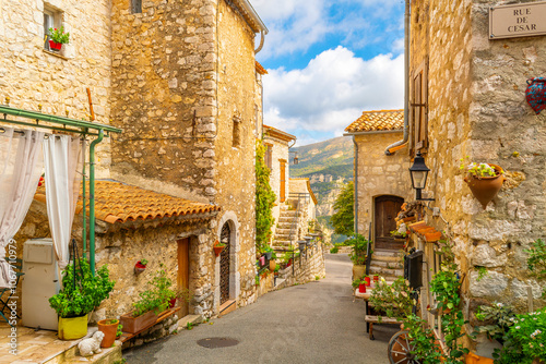 Fototapeta Naklejka Na Ścianę i Meble -  A picturesque narrow alley of shops in the medieval old town center of the hilltop village of Gourdon, France, in the Alpes-Maritimes region of Southern France.