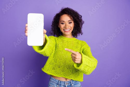 Photo of curly american young funky girl in green sweater pointing finger smartphone touchscreen isolated on purple color background