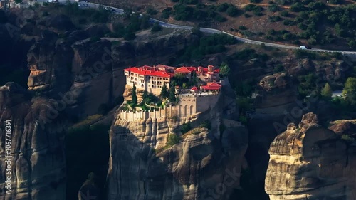 Sunlight illuminates the Monastery of Varlaam, a breathtaking monastery perched atop a towering rock formation in Meteora, Greece