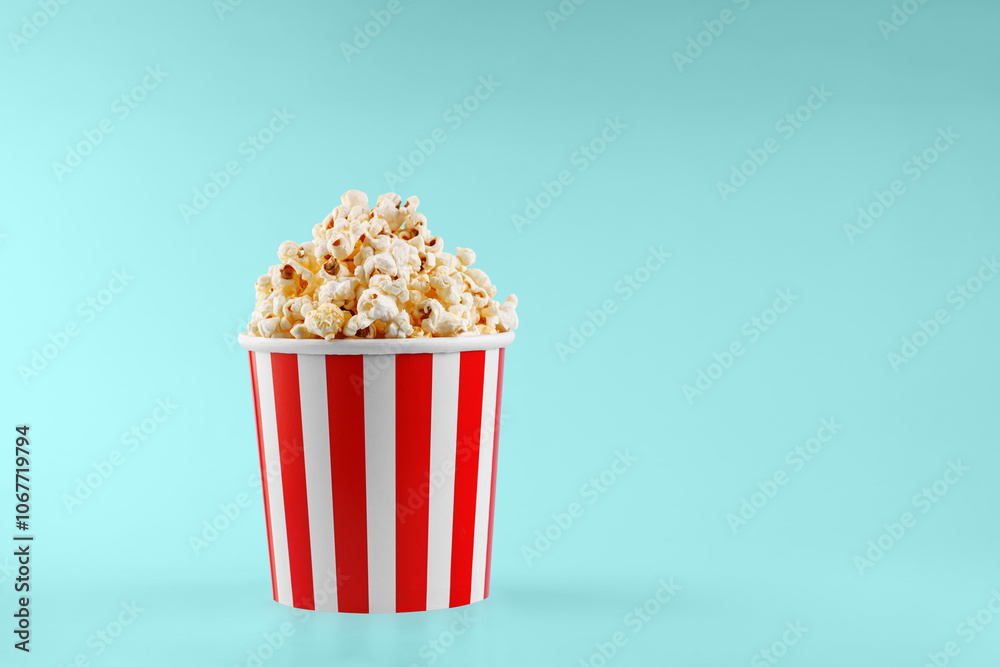Classic red striped popcorn cardboard cup on blue background Classic red striped popcorn cardboard cup on blue background