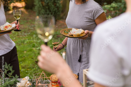 Friends enjoying wine tasting with al fresco brunch in garden