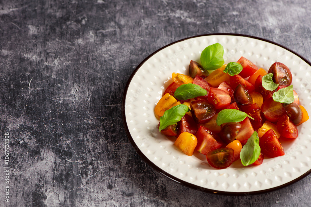 Salad with halves of red and yellow tomatoes cherry with basil Salad with halves of red and yellow tomatoes cherry with basil