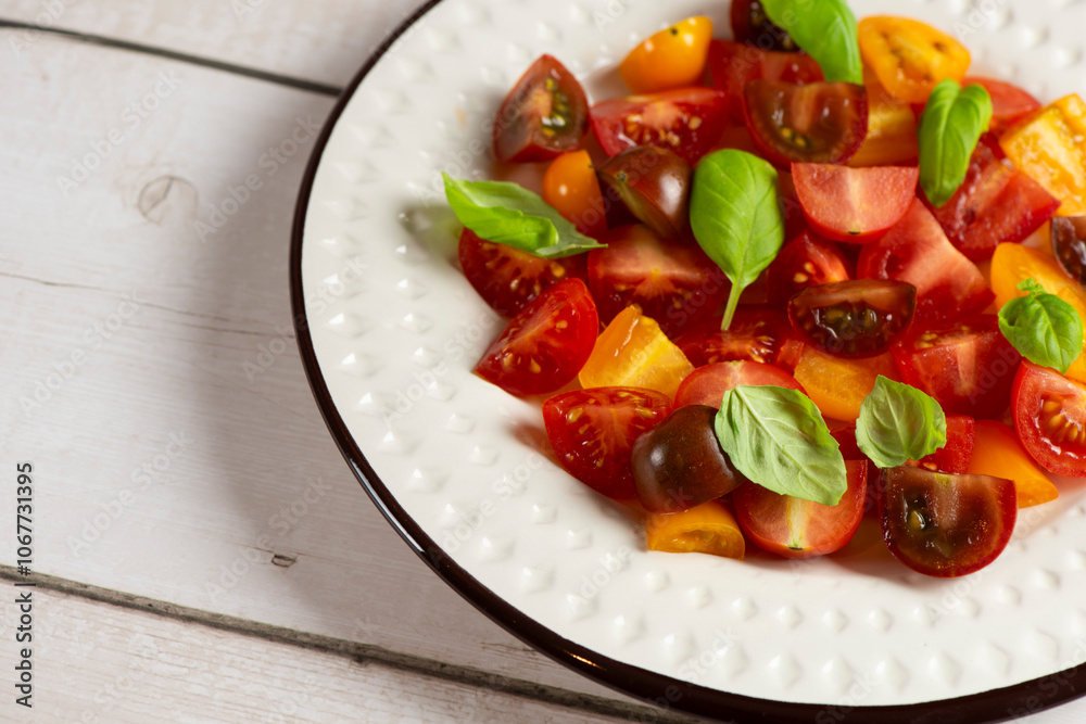 Salad with halves of red and yellow tomatoes cherry with basil Salad with halves of red and yellow tomatoes cherry with basil